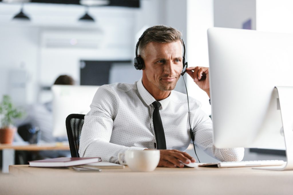 Photo of handsome man 30s wearing office clothes and headphones,