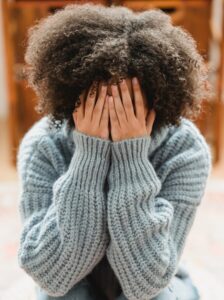 woman suffering from burnout covers her face with her hands