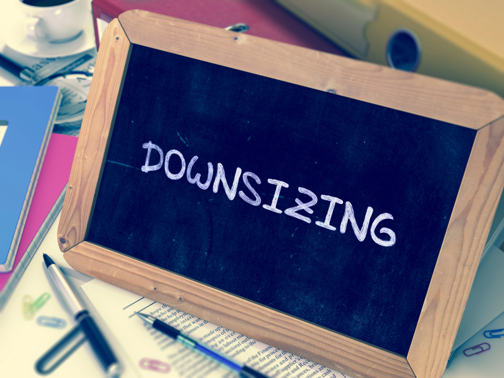 Downsizing written on blue chaukboard