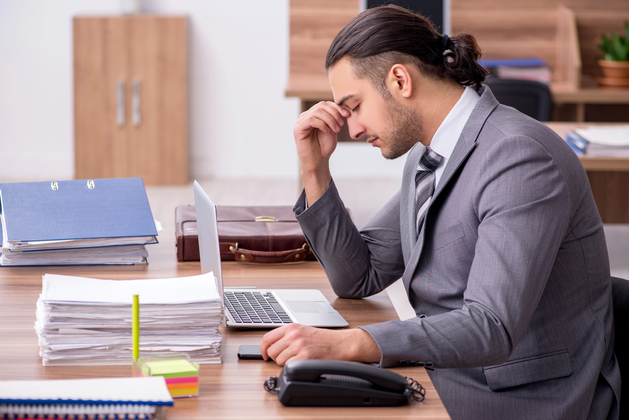 young man quietly cracking at work