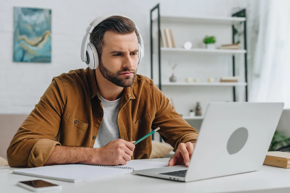 Man with headphones participating in group coaching and training online