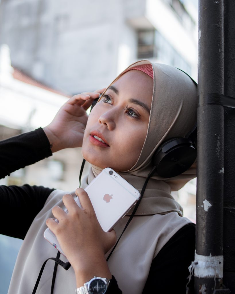 Muslim woman listens to AudioBlog while outdoors