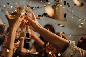 people raising glasses and toasting at holiday work party