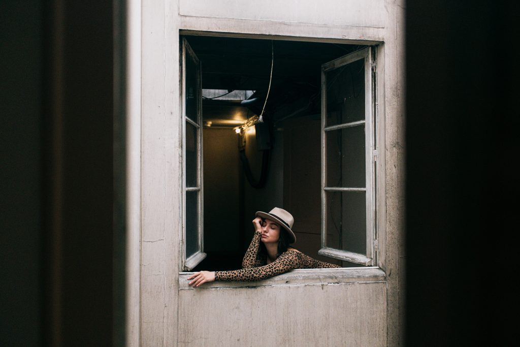 woman in window coping with pandemic grief