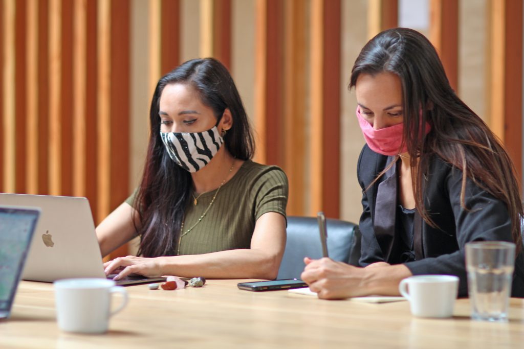 two women working in masks doing awkward communication