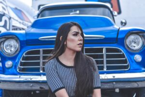 woman with burnout sits outside near her car