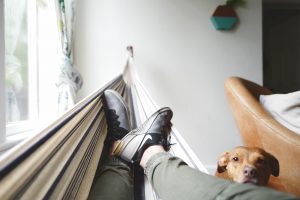 man recovers from burnout in hammock with pet dog
